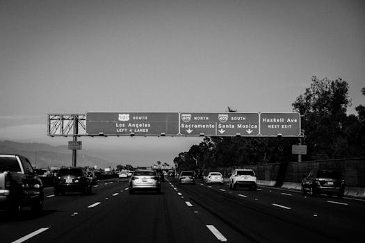 A black and white photo of a busy Los Angeles highway with visible signboards.